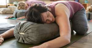 a student practicing wide knee child pose in our 2026 yin yoga and chinese medicine teacher training program in nusa lembongan bali with akirayoga